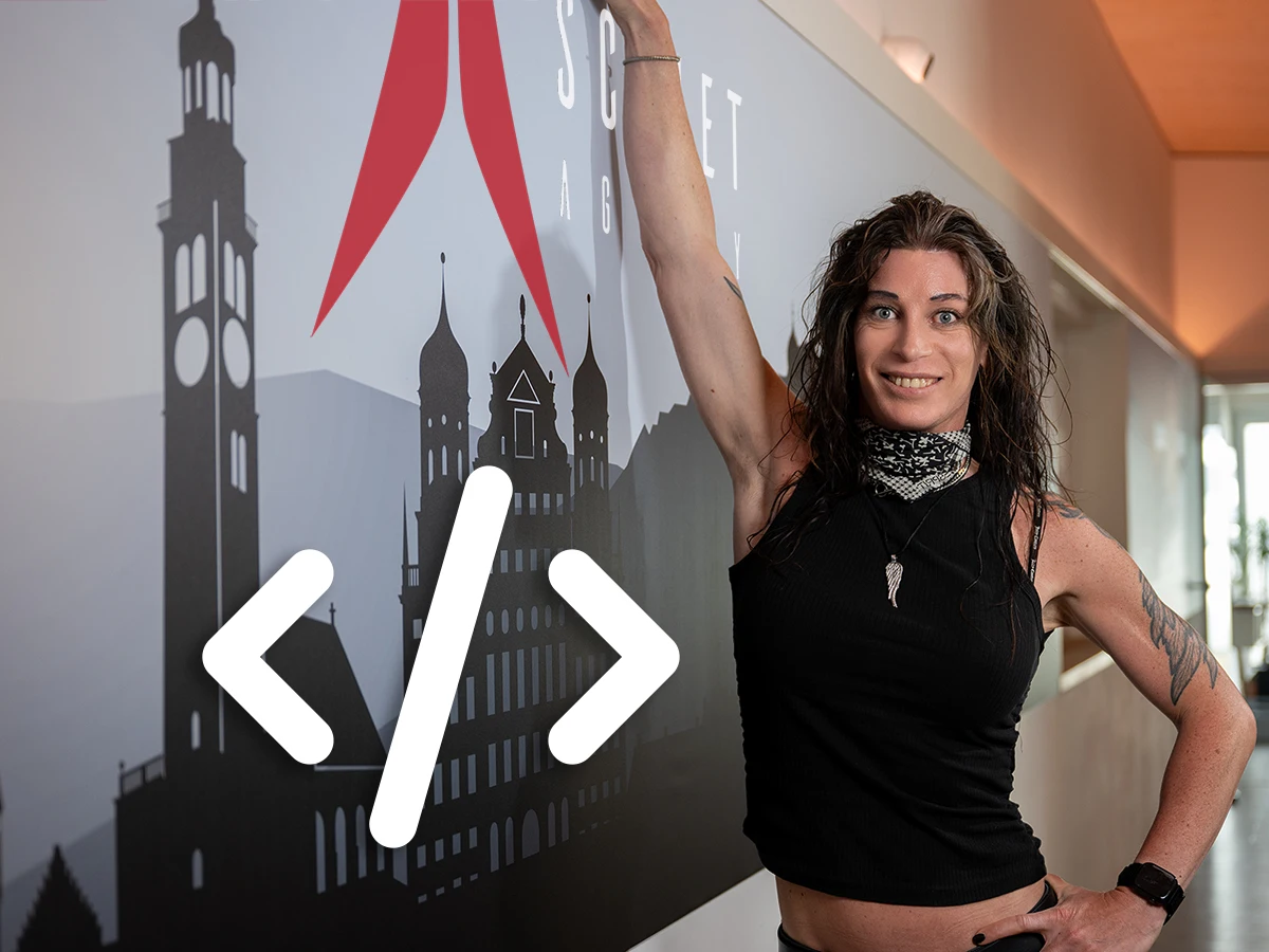 Denise Hollstein in front of the scinet studio wall with a large code symbol